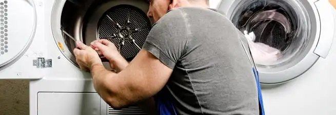 Dryer repair technician fixing a clothes dryer drum in Clearwater, FL