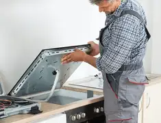 Appliance repair technician installing a built-in cooktop in Clearwater, FL