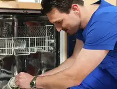 Dishwasher repair technician inspecting and servicing an open dishwasher in Clearwater, FL