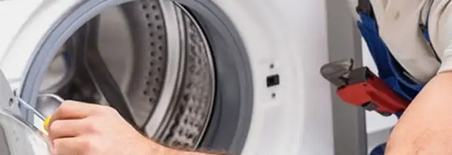 Appliance technician repairing a clothes dryer drum and internal parts in Clearwater, FL