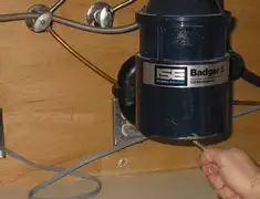 Garbage disposal repair technician tightening the mounting ring under a sink in Clearwater, FL