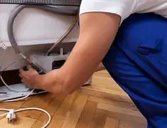Appliance repair technician fixing refrigerator water line and connections in Clearwater, FL