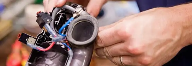 Vacuum repair technician reconnecting wiring and components in Clearwater, FL