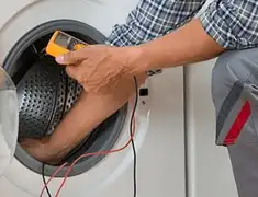 Washing machine repair technician testing a front-load washer with diagnostic tools in Clearwater, FL