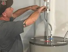 Water heater repair technician tightening supply line connections in Clearwater, FL