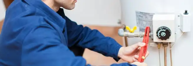Water heater repair technician adjusting the temperature control and gas valve in Clearwater, FL